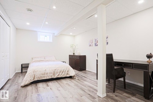 Finished interior space featuring wood-finish flooring, recessed lighting, and a white drop ceiling - 9523 151 Street, Edmonton, AB - Indoor Photo Showing Bedroom