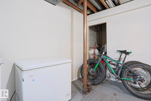 Unfinished utility area with concrete flooring, exposed ceiling joists, and a partial wall separation - 9523 151 Street, Edmonton, AB - Indoor