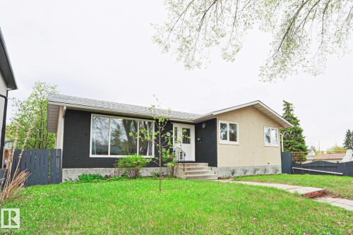 Ranch-style exterior featuring a painted brick facade and a contrasting stucco finish - 9523 151 Street, Edmonton, AB - Outdoor
