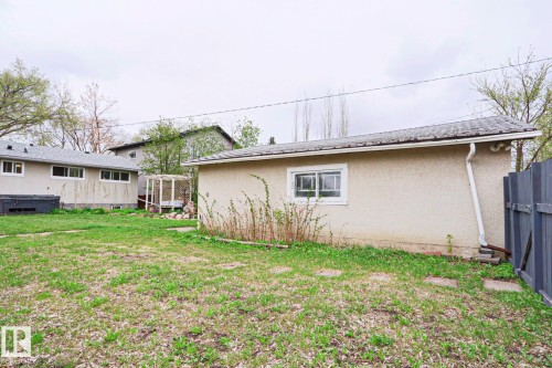 Detached structure with stucco exterior, a shingled roof, and a visible window, situated on a grassy lot - 9523 151 Street, Edmonton, AB - Outdoor