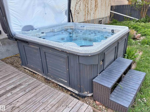 Outdoor hot tub featuring a slatted grey surround and a two-step entry - 9523 151 Street, Edmonton, AB - Outdoor With Deck Patio Veranda With Exterior