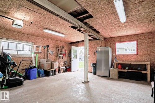 Utility space featuring concrete flooring, exposed ceiling joists, and multiple windows - 9523 151 Street, Edmonton, AB - Indoor