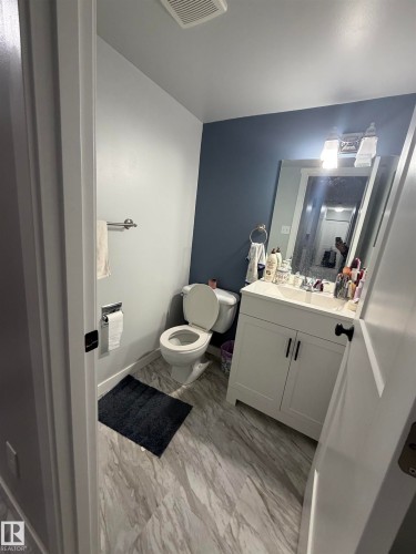 Contemporary bathroom featuring a white vanity with double-door cabinetry, a single basin sink, and an overhead light fixture - 205 10136 160 Street, Edmonton, AB - Indoor Photo Showing Bathroom