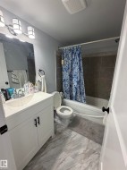 Contemporary bathroom featuring a white vanity with integrated sink, rectangular mirror, and three-light vanity bar - 
