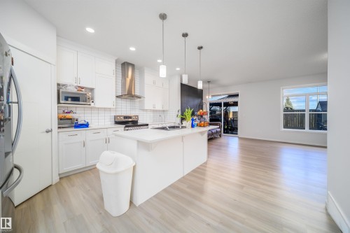 Modern kitchen featuring white shaker cabinetry, stainless steel appliances, a subway tile backsplash, and an island with pendant lighting - 9651 229 Street, Edmonton, AB - Indoor Photo Showing Kitchen With Upgraded Kitchen