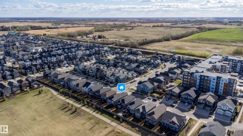 Aerial perspective showcasing a residential development with a variety of single-family homes and a multi-story apartment building - 9651 229 Street, Edmonton, AB - Outdoor With View