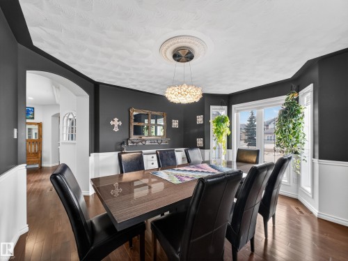 Dining area with hardwood flooring, a contemporary chandelier, and a bay window - 1062 Tory Road, Edmonton, AB - Indoor Photo Showing Dining Room