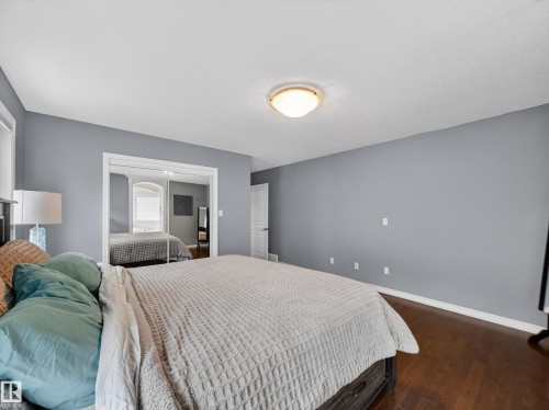 Spacious room featuring wood-finish flooring, light gray wall paint, white trim, and a white ceiling - 1062 Tory Road, Edmonton, AB - Indoor Photo Showing Bedroom