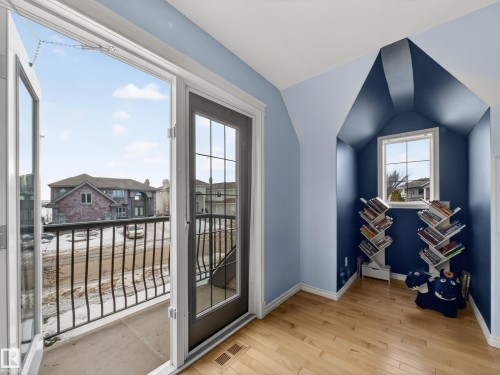 Room featuring a private balcony with wrought iron railing, French doors, and wood-finish flooring - 1062 Tory Road, Edmonton, AB -  Photo Showing Other Room
