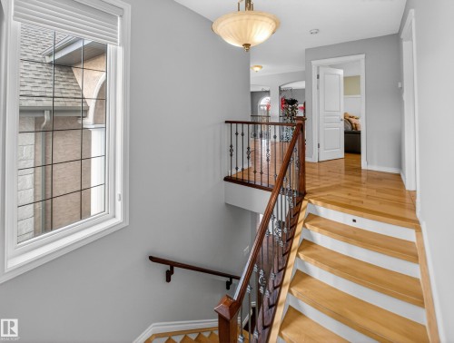 Hardwood staircase featuring dark wood newel posts and wrought iron spindles - 1062 Tory Road, Edmonton, AB - Indoor Photo Showing Other Room