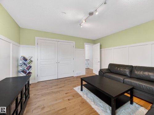 Room featuring wood-finish flooring, white paneled wainscoting, and a light green wall finish - 1062 Tory Road, Edmonton, AB - Indoor