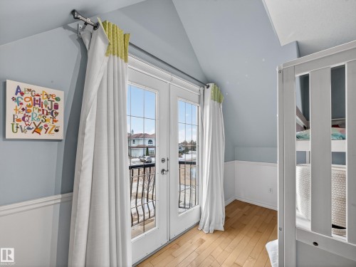 French doors with transom windows open to an exterior balcony with wrought iron railing - 1062 Tory Road, Edmonton, AB - Indoor Photo Showing Other Room