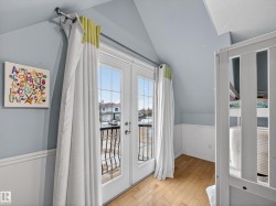 French doors with transom windows open to an exterior balcony with wrought iron railing - 