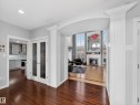 Rich wood-finish flooring throughout the entry, leading to an arched doorway with decorative pilasters - 1062 Tory Road, Edmonton, AB  - Indoor 