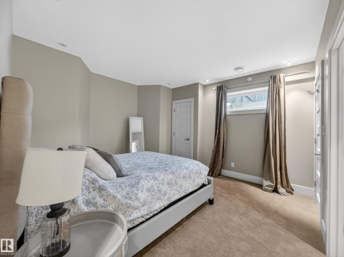 Neutral-toned walls complement the recessed lighting and window with drapes - 1062 Tory Road, Edmonton, AB - Indoor Photo Showing Bedroom