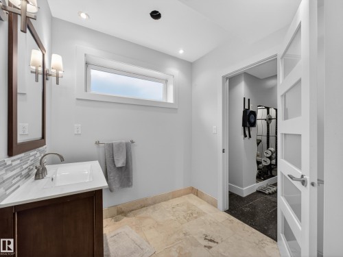Bathroom vanity featuring a quartz countertop, rectangular undermount sink, and mosaic tile backsplash - 1062 Tory Road, Edmonton, AB - Indoor Photo Showing Bathroom