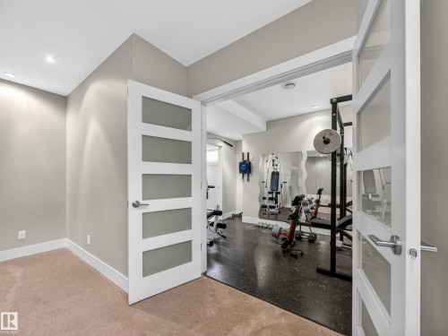 Dedicated fitness room featuring dark flooring, recessed lighting, and mirrored wall accents - 1062 Tory Road, Edmonton, AB - Indoor Photo Showing Gym Room