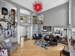 Two-story living area featuring a vaulted ceiling and an ornate red light fixture - 