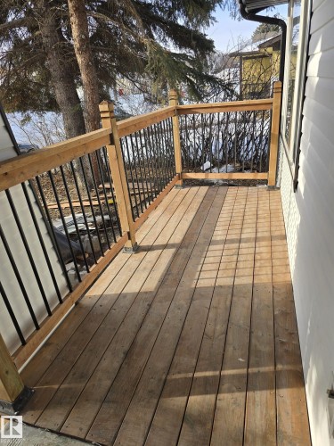 Wood-finish deck with natural wood railing and black metal balusters - 11628 151 Avenue, Edmonton, AB - Outdoor With Deck Patio Veranda