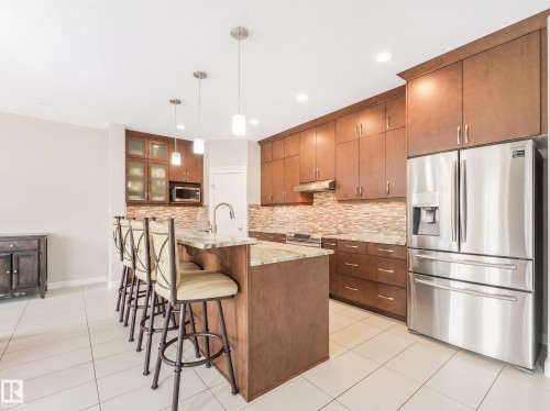 Enjoy upgraded floor-to-ceiling kitchen cabinets featuring soft-close drawers and elegant under-cabinet lighting. - 17703 9A Avenue, Edmonton, AB - Indoor Photo Showing Kitchen With Upgraded Kitchen