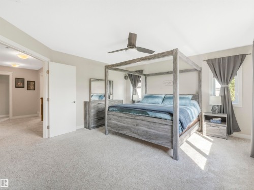 The primary bedroom features extra windows that fill the space with natural light and showcase breathtaking views of your private backyard oasis. - 17703 9A Avenue, Edmonton, AB - Indoor Photo Showing Bedroom
