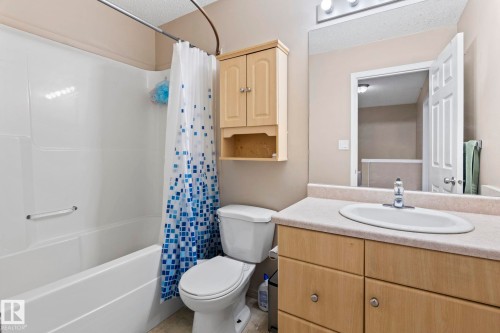 Bathroom featuring a white tub/shower combination, light wood-finish vanity with a single basin sink, and overhead illumination - 92 4350 23 Street, Edmonton, AB - Indoor Photo Showing Bathroom