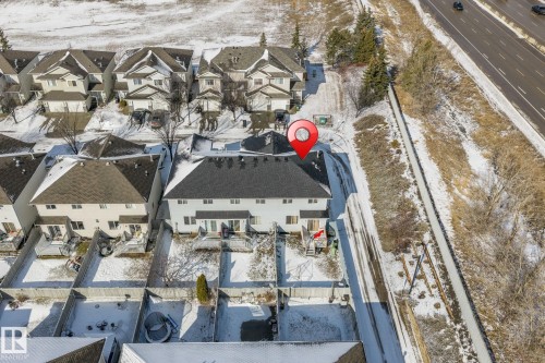 Aerial overview of the property featuring a two-story residence with a dark shingled roof and light-colored siding - 92 4350 23 Street, Edmonton, AB - Outdoor