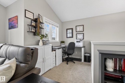 Loft space featuring vaulted ceilings, a window, built-in white cabinetry, a built-in desk, and carpet flooring - 2146 Austin Link Link, Edmonton, AB - Indoor