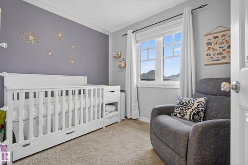 Bedroom featuring light-colored carpet flooring and a window with white casing and mullions - 2146 Austin Link Link, Edmonton, AB - Indoor Photo Showing Bedroom