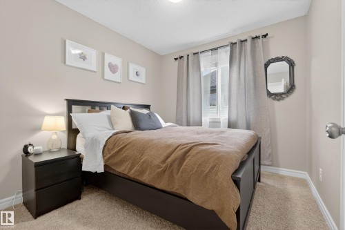 Carpeted bedroom featuring light-toned walls and a window with natural light - 2146 Austin Link Link, Edmonton, AB - Indoor Photo Showing Bedroom