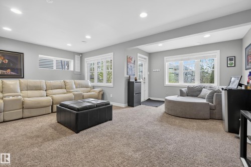 Carpeted room featuring recessed lighting, light gray walls, white trim, and a large window with exterior views - 2146 Austin Link Link, Edmonton, AB - Indoor Photo Showing Living Room