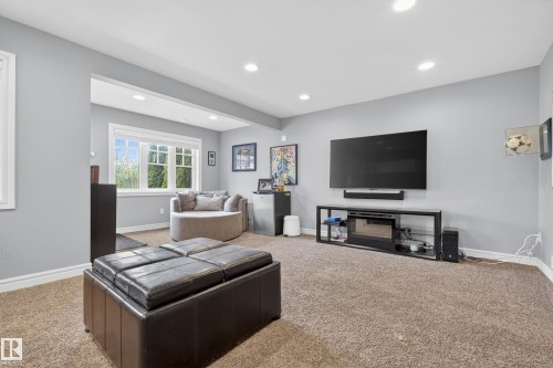 Recessed lighting illuminates this carpeted room featuring light gray walls, a window with white trim and muntins, and white baseboards - 2146 Austin Link Link, Edmonton, AB - Indoor Photo Showing Living Room