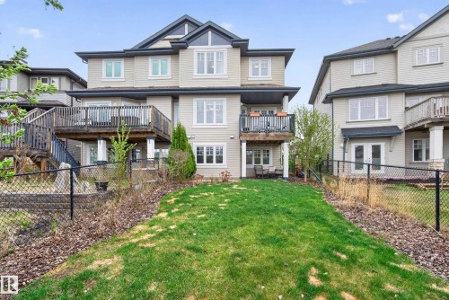 Spacious backyard featuring a sloped lawn and mature landscaping - 2146 Austin Link Link, Edmonton, AB - Outdoor With Balcony With Deck Patio Veranda With Facade