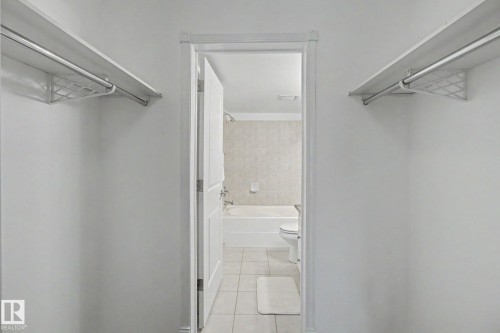 Walk-in closet featuring dual shelving and hanging rods - 213 17404 64 Avenue, Edmonton, AB 
