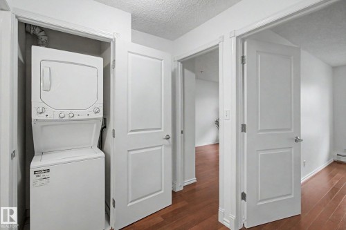 Dedicated laundry closet featuring a stacked washer and dryer unit - 213 17404 64 Avenue, Edmonton, AB 