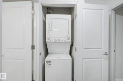Dedicated laundry closet featuring a stackable washer and dryer unit - 