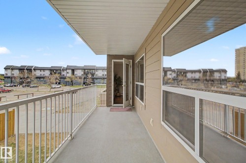 Expansive balcony featuring concrete flooring and white metal railings - 213 17404 64 Avenue, Edmonton, AB 