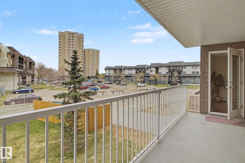 Private balcony with concrete flooring, white metal railing, and a glass-paneled door - 213 17404 64 Avenue, Edmonton, AB 