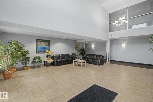Expansive foyer featuring large format tile flooring and a double-height ceiling - 213 17404 64 Avenue, Edmonton, AB 