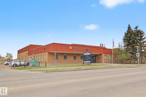 Single-story commercial building featuring brick and metal siding construction, multiple windows, and a prominent entry - 213 17404 64 Avenue, Edmonton, AB 