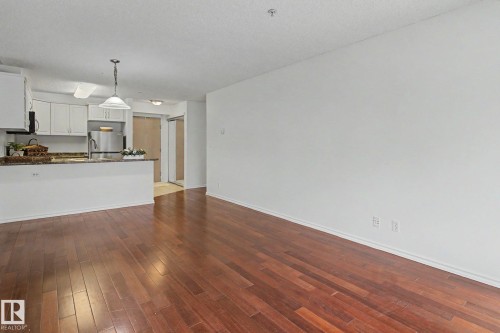 Open-concept living space with wood-finish flooring - 213 17404 64 Avenue, Edmonton, AB 