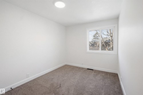 Bright interior room featuring neutral-toned carpet flooring, white painted walls, and white trim - 1706 37 Street, Edmonton, AB - Indoor Photo Showing Other Room