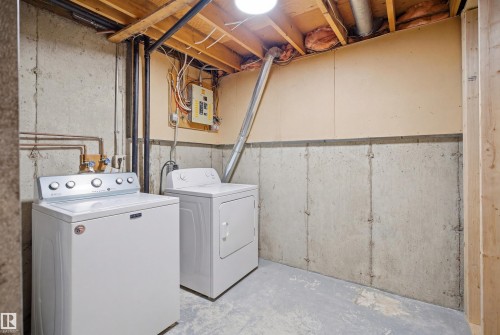 Utility space featuring concrete slab flooring, concrete foundation walls, and an exposed wood beam ceiling - 1706 37 Street, Edmonton, AB - Indoor Photo Showing Laundry Room