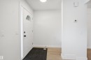 Entryway featuring a white paneled front door with an arched transom window, a sidelight, and matte black hardware - 1706 37 Street, Edmonton, AB  - Indoor Photo Showing Other Room 