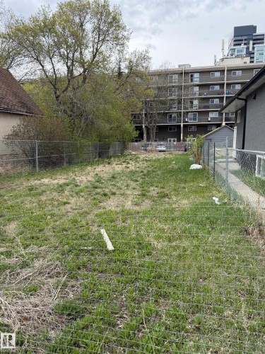 Expansive lot featuring established chain-link fencing and mature trees - 9345 103A Avenue, Edmonton, AB 