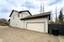 Attached garage with a light-colored sectional door, asphalt shingle roofing, and light-colored horizontal siding - 2016 125 Street, Edmonton, AB  - Outdoor With Exterior 