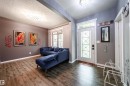 Entryway featuring wood-finish flooring, a decorative glass-paneled door with a transom window, and a built-in recessed ceiling light fixture - 2016 125 Street, Edmonton, AB  - Indoor 
