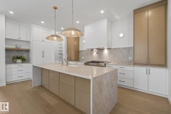 Kitchen featuring a large central island with a stone-finish countertop, wood-finish cabinetry, and under-counter storage - 