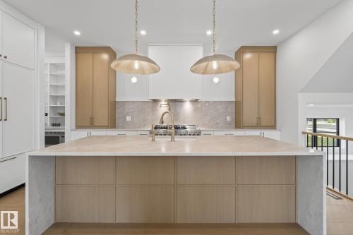 Expansive kitchen island with a light-toned countertop and wood-finish cabinetry - 13804 85 Avenue, Edmonton, AB - Indoor Photo Showing Kitchen With Upgraded Kitchen