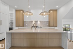 Expansive kitchen island with a light-toned countertop and wood-finish cabinetry - 